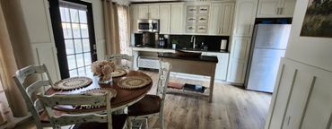 Cozy kitchen with round dining table and white cabinetry.