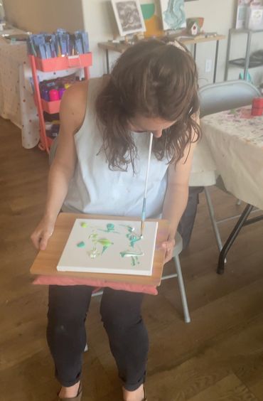 A woman painting on a piece of paper