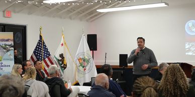 A speaker showcasing new initiatives in Los Alamitos presenting to an audience. 