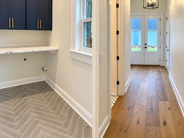 Laundry room and hallway with wood and tile flooring.