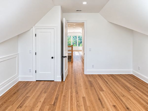 Empty room with hardwood flooring and white walls.