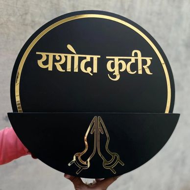 Black and gold nameplate with Hindi text and folded hands symbol.