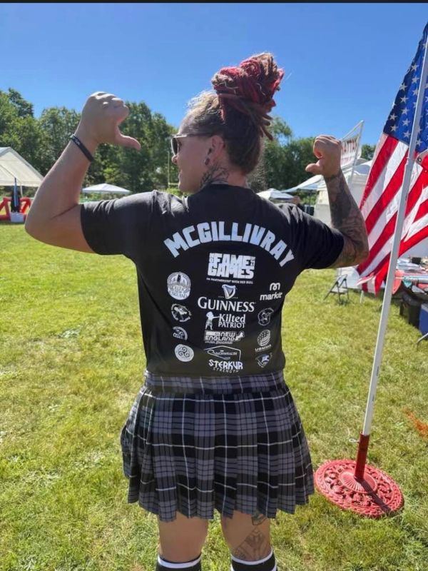 Person flexing back muscles wearing a McGillivray event shirt.
