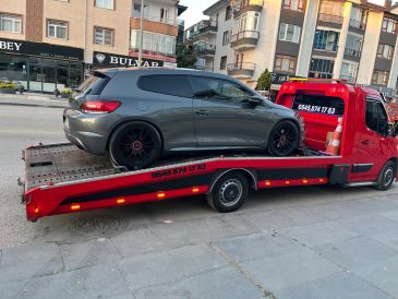 Kırmızı çekici üzerinde gri spor araba.