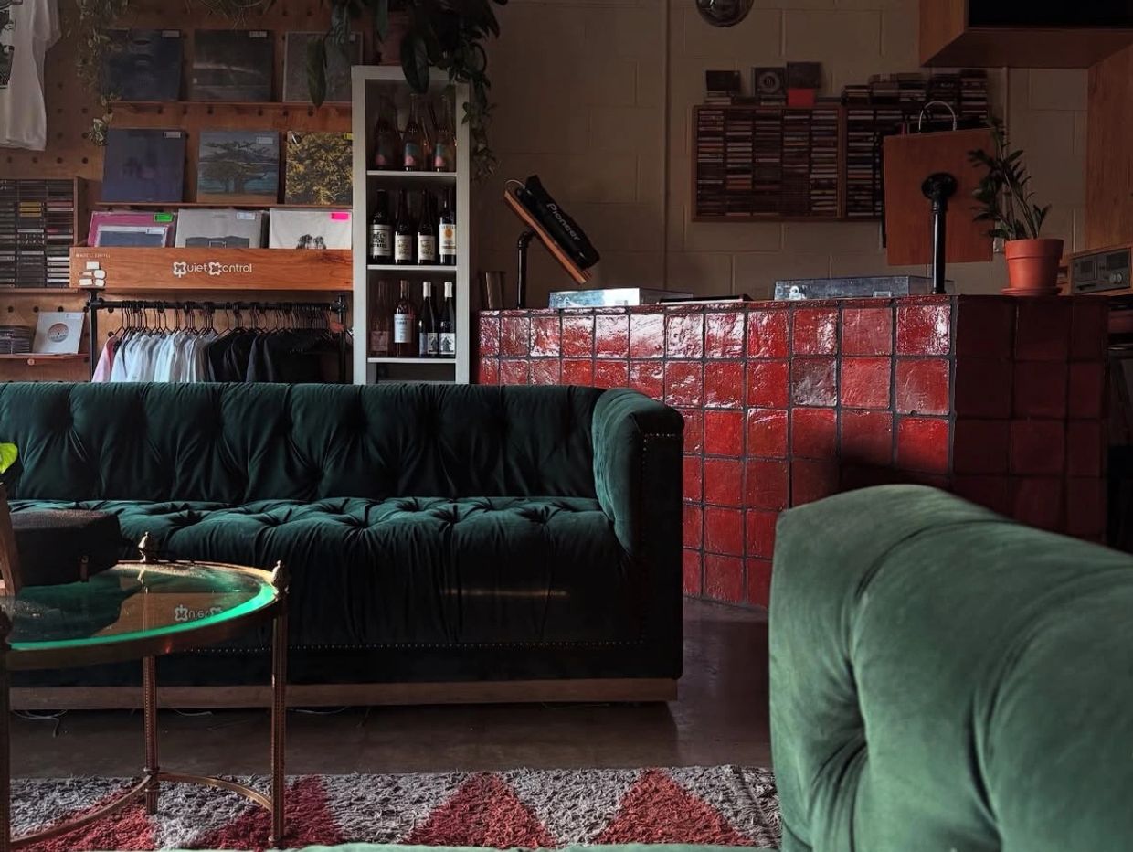 Cozy room with green velvet sofas and red tile counter.