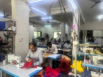 Workers sewing clothes in a busy workshop.