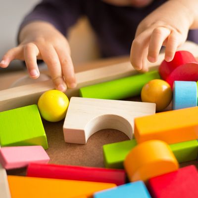Young child sorting colorful wooden blocks