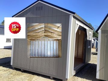 A gray garden shed with open door and window frame, 15% off sale.