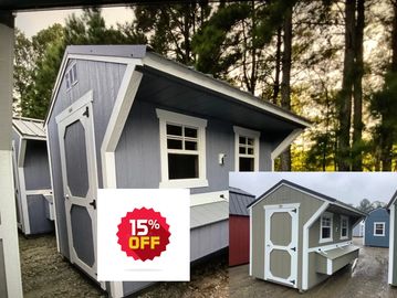 Small gray wooden shed with white trims in a forest setting.