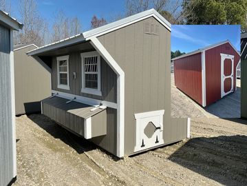 A small gray chicken coop with white trim and a nesting box outside.