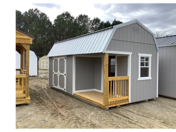 Gray wooden shed with white trim and small porch under a cloudy sky.