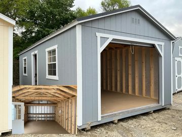 A newly built gray wooden garage with an open front and white trim.