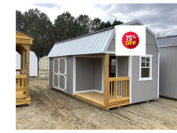 Gray wooden shed with white trim and small porch under a cloudy sky.