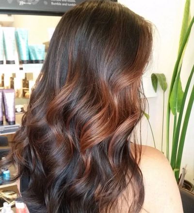 Long, wavy brown hair with subtle red highlights.