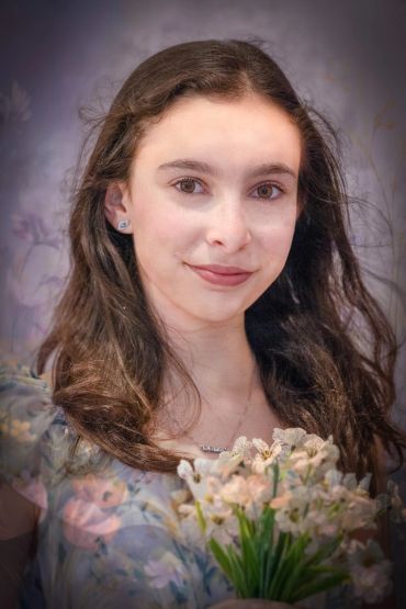 Young woman with flowers and soft lighting.