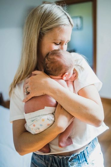Mother tenderly holding and kissing her baby.