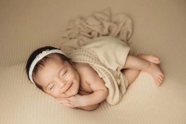 Smiling newborn baby girl sleeping peacefully.