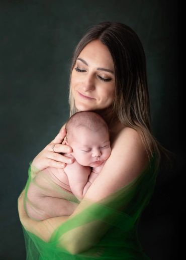 Mother tenderly holding her sleeping baby.