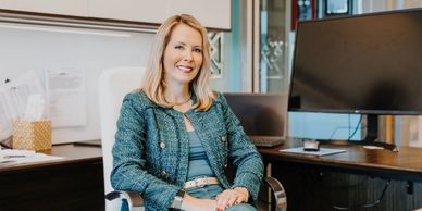 Smiling businesswoman sitting in a modern office chair by her desk.