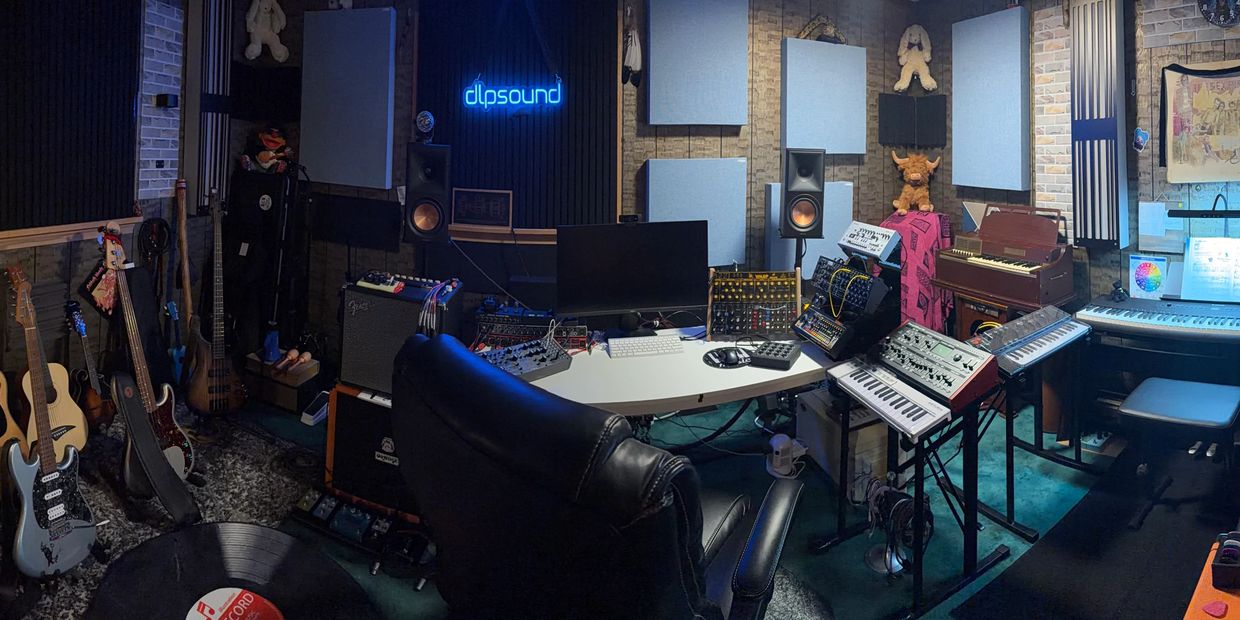 Cozy music studio with instruments, synthesizers, and sound equipment.