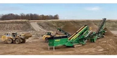 Heavy machinery operating at a construction site with dirt and gravel.