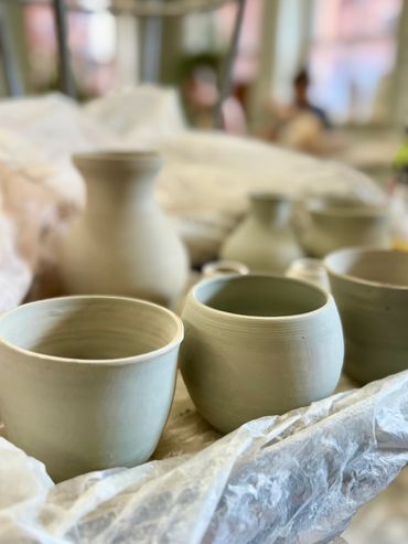 Unfinished pottery on a table in a workshop.