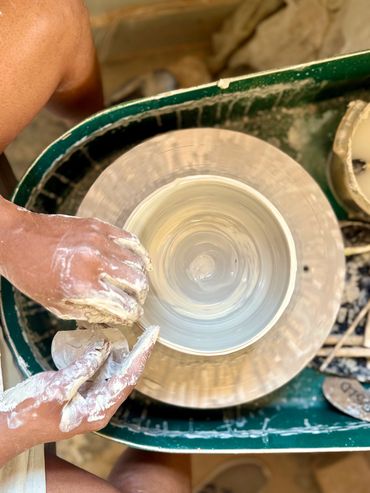 Pottery wheel shaping a clay pot.