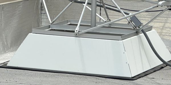 Metal structure base with cables on a rooftop.