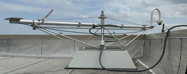 Rooftop weather monitoring equipment with sensors and cables.