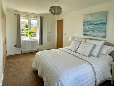 a beautiful bedroom with comfortable bed and luxurious bedding, with views to the sea