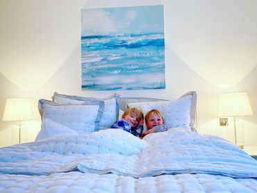 a beautiful bedroom with comfortable bed and luxurious bedding, with views to the sea