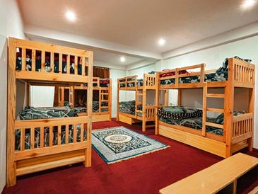 Room with four wooden bunk beds and a carpet.