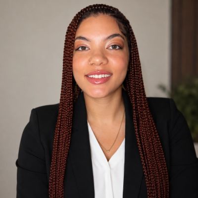Professional woman with long braided hair smiling confidently.