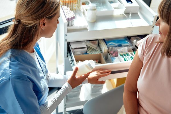 Healthcare professional explaining medication to a patient in a clinic.