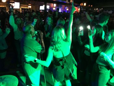 People enjoying live music in a crowded, lively nightclub.