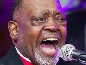 Man passionately singing into a microphone.