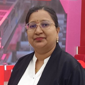 A woman with glasses wearing traditional earrings and a bindi.