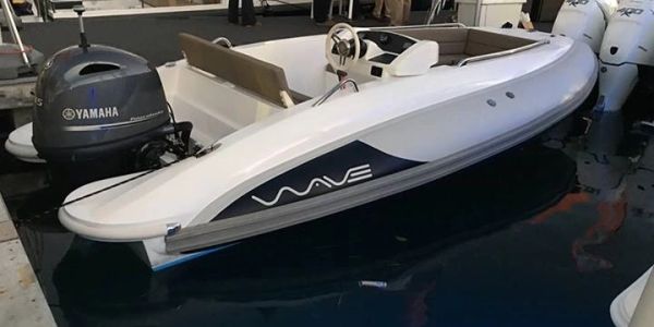 White motorboat with Yamaha engine docked indoors.