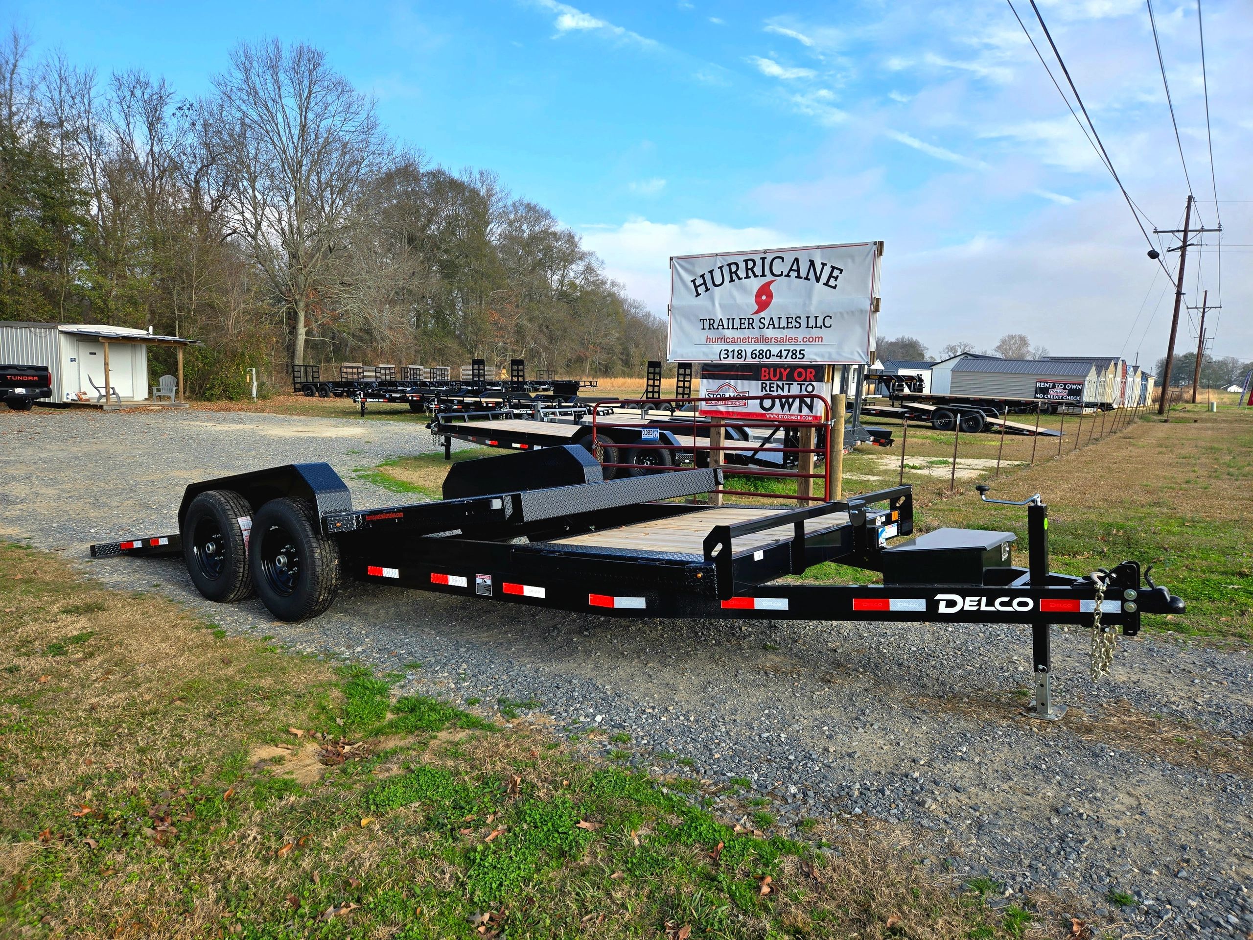 Black Delco trailer on gravel at Hurricane Trailer Sales lot.