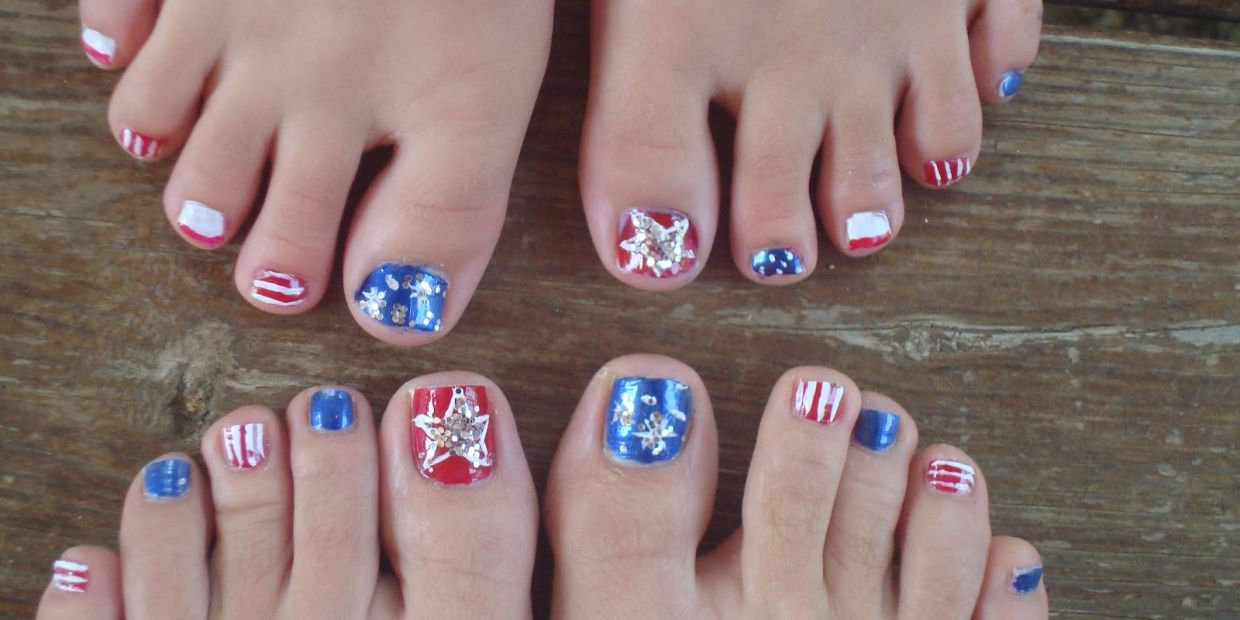 Two pairs of feet with patriotic red, white, and blue toenail art featuring stars and stripes.