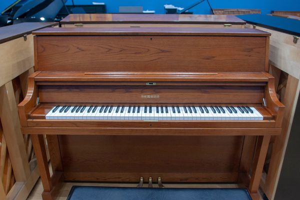 Wooden upright piano in a showroom.