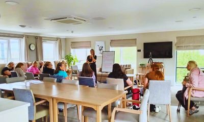 Group meeting in a bright room with large windows.