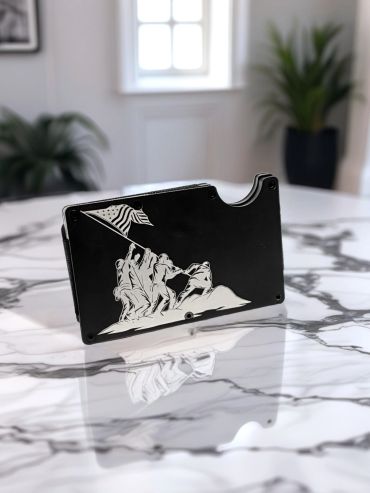 Black cardholder with Iwo Jima flag-raising design on a marble table.
