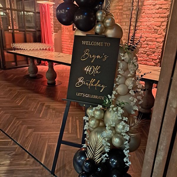 Elegant welcome sign with black and gold balloons for Bryn's 40th birthday celebration.