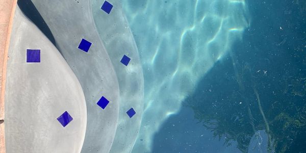 Swimming pool steps with blue tile accents.