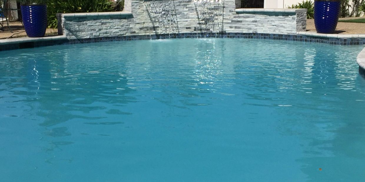 Clear blue pool with stone water features.