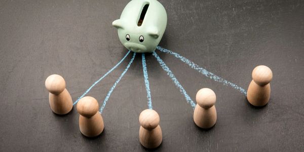 Piggy bank with chalk lines connecting to wooden figurines.