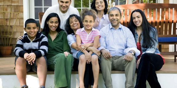 A happy family posing outdoors on steps.