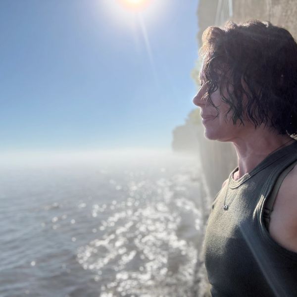 Person enjoying sunlight by the water.