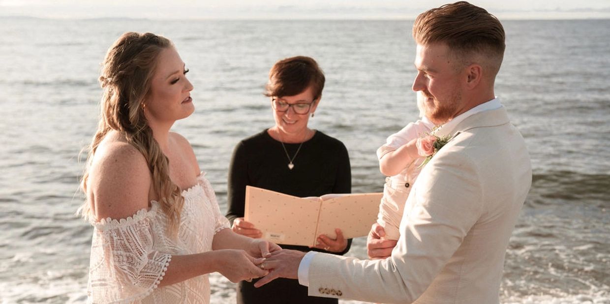 Bride, groom, Justice of Peace and small child being married on Nova Scotia beach elopement.